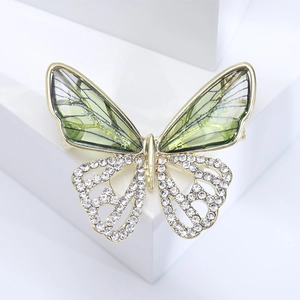 Detailed close-up of butterfly brooch with green translucent wings and white crystals