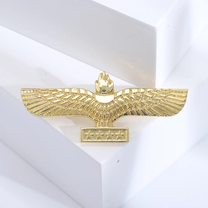 Detailed view of a golden eagle brooch featuring wings and four stars on a white pedestal