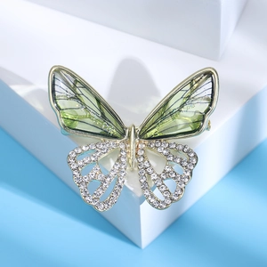 Macro detail of elegant hollow butterfly brooch with green wings and sparkling crystals