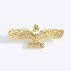 Detailed close-up of a gold eagle brooch with star-engraved bar and polished metal finish