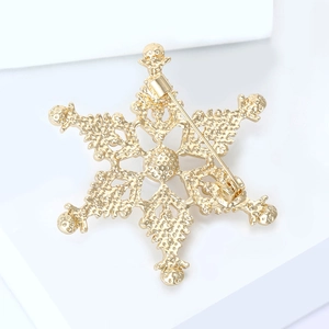 Vue détaillée du dos d'une broche flocon dorée avec épingle et finition texturée