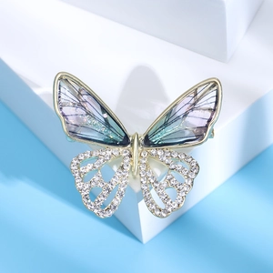 Macro shot of butterfly brooch with blue gradient wings and crystals on geometric stands