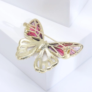 Detail view of the butterfly brooch back showing the secure long needle pin and gold metal plating