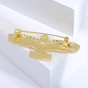 Detail view of the golden eagle brooch back showing a secure long pin and polished metal finish
