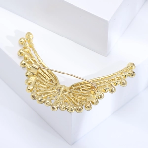 Détail du dos de la broche ailes dorées montrant le mécanisme d'épingle et la texture alliage
