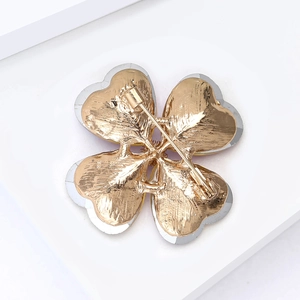 Detail view of the four-leaf clover brooch back with secure safety pin clasp and gold plating