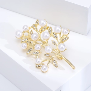 Elegant gold tree brooch with white pearls and sparkling rhinestones on white cubes
