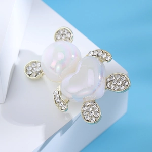 Dettaglio di una spilla a forma di orsetto con corpo a cuore e pavé di strass scintillanti