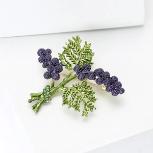 Detail of lavender brooch with purple floral clusters and green rhinestone accents