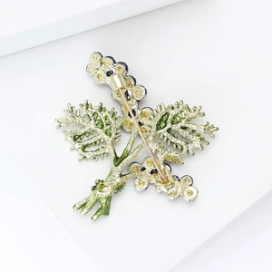 Detailed back view of a botanical brooch with golden pin and vibrant enamel finish
