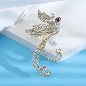 Détail macro d'une broche oiseau avec strass étincelants et une perle centrale