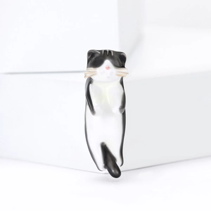 Cute black and white enamel cat brooch with pink nose on minimalist geometric display