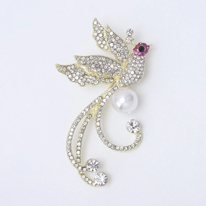 Détail macro d'une broche phénix avec strass en cristal et incrustation de perles
