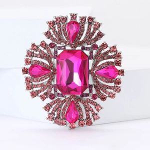 Dettaglio di una spilla di lusso con cristallo rosa rettangolare e montatura argento