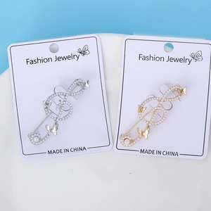 Detail of music note brooches with gold and silver plating featuring pearls and butterflies
