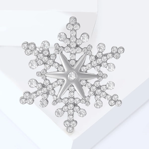 Macro shot of silver snowflake brooch with sparkling rhinestones and crystal inlay details