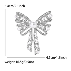 Detailed size view of silver bow brooch with pearls and rhinestones measuring 5.4 by 4.5 cm