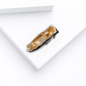 Detailed close-up of the cat brooch back showing gold alloy plating and safety pin clasp