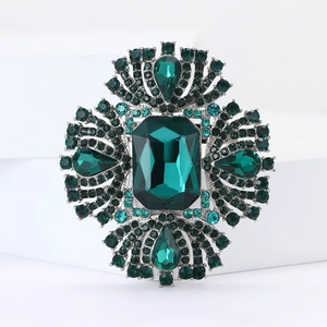 Dettaglio macro della spilla di lusso con cristalli verde smeraldo e placcatura argento