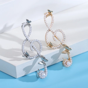 Detailed macro view of musical note brooch with pearls and butterfly on blue background