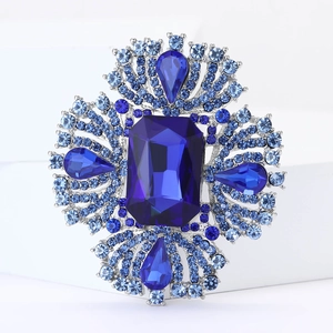 Elegante spilla in lega d'argento con grande cristallo blu e strass blu su fondo bianco