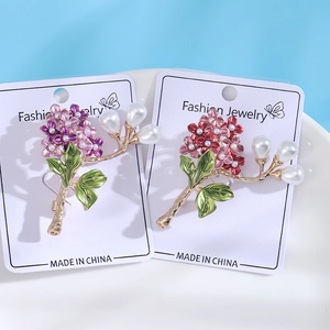 Floral hydrangea brooch pins with colorful enamel leaves and pearls in a white tray