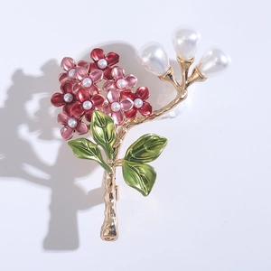 Macro view of hydrangea brooch with red enamel petals and white pearls in gold plating