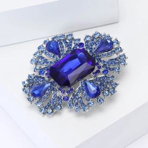 Dettaglio macro di una lussuosa spilla in cristallo blu con lega d'argento e pietre preziose