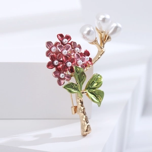 Detail of floral brooch with enamel petals, white teardrop pearls and golden branch