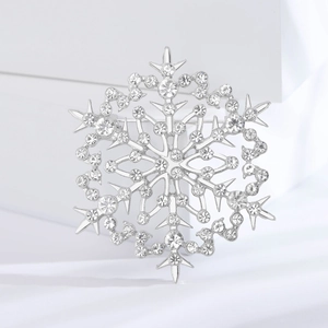 Broche flocon de neige hivernale avec zircons sur fond élégant en soie blanche pure