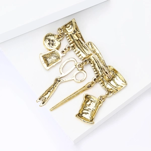Detailed close-up of vintage golden tailor tool brooch featuring scissors and tape measure