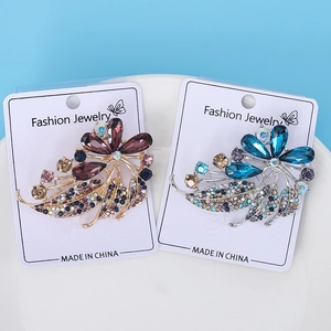 Detail view of gold and silver crystal flower brooches with purple and blue stones