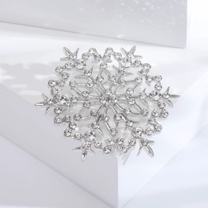Détail d'une broche flocon de neige argentée ornée de strass et de cristaux étincelants