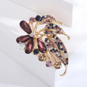 Detail of flower brooch with purple pear crystals and blue rhinestones on gold base