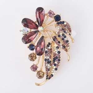 Detail of flower brooch with purple crystal petals and multi-colored rhinestones on gold base