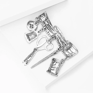 Macro detail of vintage silver sewing machine tools brooch with scissors and thread spool