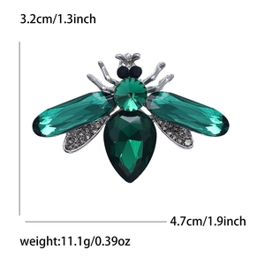 Detailed size view of bee insect brooch with green gemstones and sparkling crystals