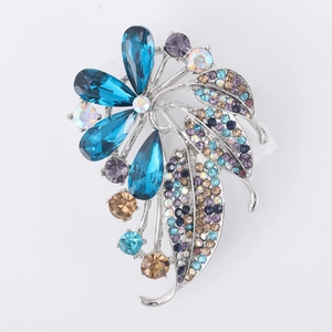 Macro detail of elegant flower brooch with blue crystal petals and colorful rhinestones