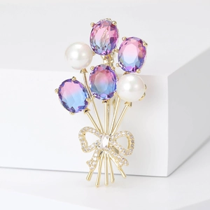 Broche bouquet de ballons avec cristaux violets, perles et nœud en zircone sur base dorée