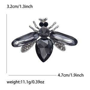 Detailed view of silver bee brooch with grey crystals and dimensions 3.2cm by 4.7cm