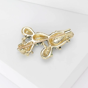 Back view of a gold alloy cactus brooch showing a secure pin clasp on white pedestal