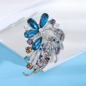 Detailed close-up of blue crystal flower brooch with colorful rhinestones on silver base