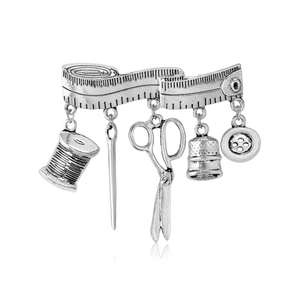 Vintage silver sewing theme brooch with dangling scissors, thimble, and button charms