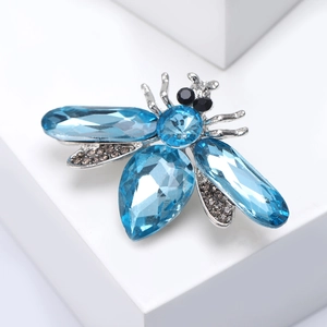 Detailed macro view of bee brooch with blue crystal wings and silver metal frame