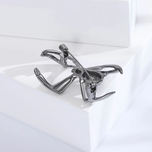 Detail shot of spider brooch back showing a long gunblack pin fastener on alloy base