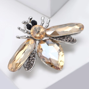 Macro shot of bee lapel pin showing champagne crystals and silver alloy details