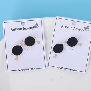 Detail of gold and silver sunglasses brooches with rhinestones on a ceramic tray