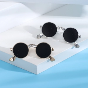 Macro shot of stylish gold and silver sunglasses brooches with sparkling rhinestone details