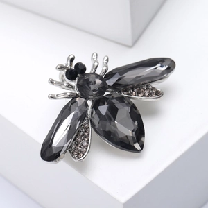 Macro detail of bee insect brooch featuring smoky grey crystals on silver alloy base