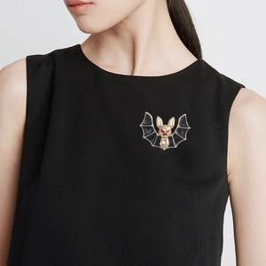 Gothic bat brooch in gold and black enamel pinned on a black dress for styling